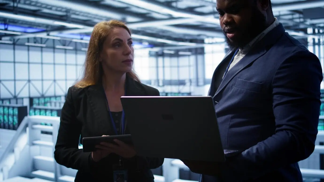 Коллеги в серверной оптимизируют аппаратное оборудование центра обработки данных.